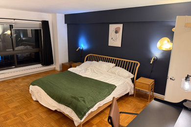 Large trendy light wood floor and beige floor bedroom photo in New York