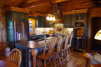 Inspiration for a mid-sized rustic l-shaped light wood floor and brown floor eat-in kitchen remodel in Other with a farmhouse sink, raised-panel cabinets, green cabinets, granite countertops, multicolored backsplash, stone tile backsplash, stainless steel appliances and an island