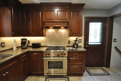 Eat-in kitchen - mid-sized traditional l-shaped ceramic tile eat-in kitchen idea in Other with an undermount sink, raised-panel cabinets, dark wood cabinets, quartz countertops, white backsplash, subway tile backsplash, paneled appliances and no island