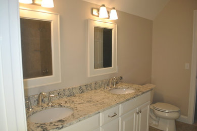 Example of a master bathroom design in Bridgeport with white walls and marble countertops