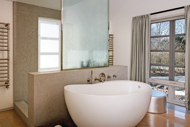 Photo of a contemporary bathroom in New York with a freestanding tub, an open shower, beige tile and an open shower.