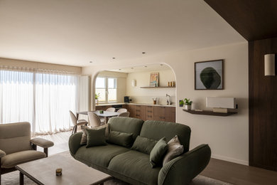 Réalisation d'un salon beige et blanc de taille moyenne avec un téléviseur encastré, un sol marron et éclairage.