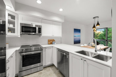 Kitchen - small transitional u-shaped laminate floor and gray floor kitchen idea in Other with a double-bowl sink, shaker cabinets, white cabinets, quartz countertops, white backsplash, porcelain backsplash, stainless steel appliances and white countertops