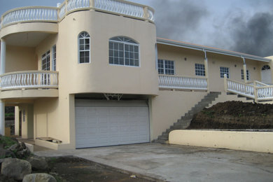 Imagen de fachada de casa beige y marrón mediterránea grande de dos plantas con revestimiento de adobe, tejado plano y tejado de metal