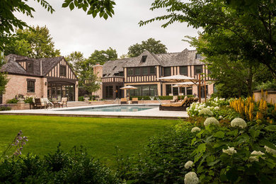 This is an example of a large traditional full sun backyard stone water fountain landscape in Chicago for summer.
