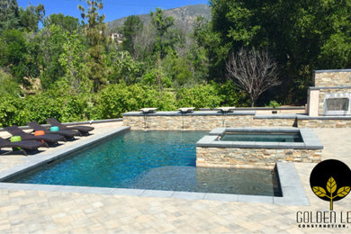 Example of a mid-sized trendy backyard concrete paver and rectangular natural hot tub design in Los Angeles