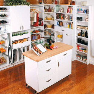 Inspiration for a large traditional l-shaped kitchen pantry in New York with flat-panel cabinets, white cabinets, wood benchtops, medium hardwood floors and with island.