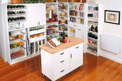 Large elegant l-shaped medium tone wood floor kitchen pantry photo in New York with flat-panel cabinets, white cabinets, wood countertops and an island