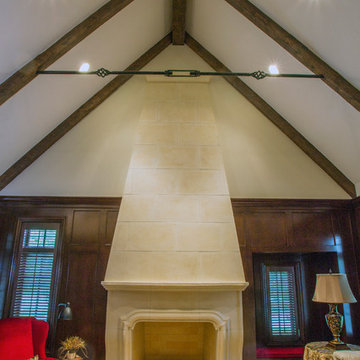 Two Story Limestone Fireplace with Stained Cherry Paneling and Beams