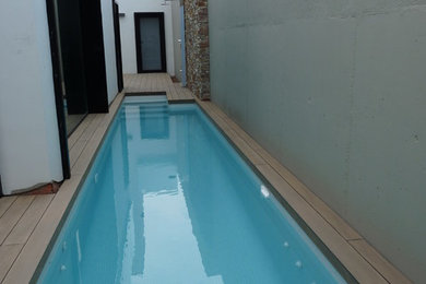 This is an example of a small modern backyard lap pool in Valencia with a pool house.