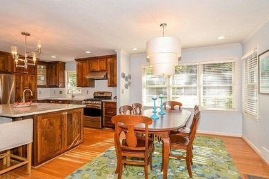 Eat-in kitchen - mid-sized traditional l-shaped medium tone wood floor and brown floor eat-in kitchen idea in San Luis Obispo with an undermount sink, shaker cabinets, dark wood cabinets, granite countertops, white backsplash, subway tile backsplash, stainless steel appliances and an island