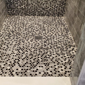 Shower design done with penny rounds on the accent wall and shower floor
