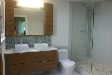 Bathroom - contemporary green tile bathroom idea in Vancouver with a vessel sink, flat-panel cabinets, medium tone wood cabinets, quartz countertops and a one-piece toilet