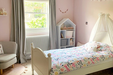Design ideas for a children’s room for girls in London with pink walls, carpet and beige floors.
