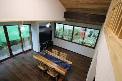 他の地域にあるモダンスタイルのおしゃれなLDK (白い壁、無垢フローリング、据え置き型テレビ、薪ストーブ、石材の暖炉まわり) の写真