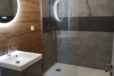 Diseño de cuarto de baño moderno de tamaño medio con ducha a ras de suelo, suelo vinílico, lavabo suspendido y suelo marrón