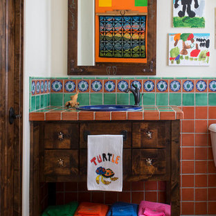 Exemple d'une salle de bain sud-ouest américain pour enfant avec des portes de placard en bois sombre, un carrelage multicolore, des carreaux en terre cuite, un lavabo posé, un plan de toilette en carrelage, un placard en trompe-l'oeil et un mur blanc.