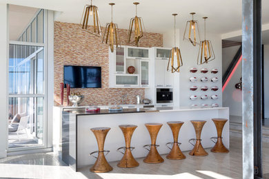 Mid-sized trendy galley porcelain tile and beige floor seated home bar photo in Other with white cabinets, quartz countertops, glass tile backsplash, multicolored backsplash and glass-front cabinets