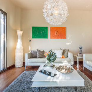 Design ideas for a medium sized mediterranean open plan living room in Other with beige walls, laminate floors, a freestanding tv and brown floors.
