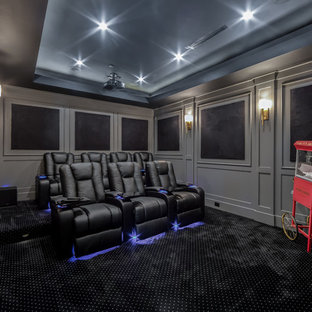 Classic enclosed home cinema in Los Angeles with grey walls, carpet and black floors.