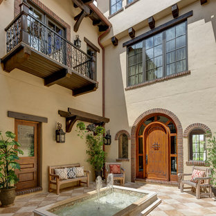 オーランドの大きい地中海スタイルのおしゃれな中庭のテラス (噴水、タイル敷き、日よけなし) の写真