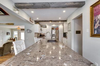 Example of a mid-sized mountain style vinyl floor eat-in kitchen design in Calgary with an undermount sink, shaker cabinets, white cabinets, granite countertops, gray backsplash, subway tile backsplash, stainless steel appliances and an island
