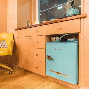 Foto de estudio minimalista, pequeño, con paredes blancas, suelo de bambú y escritorio independiente