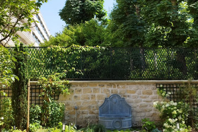 Idée de décoration pour un jardin latéral tradition de taille moyenne avec un point d'eau, une exposition partiellement ombragée et une clôture en pierre.