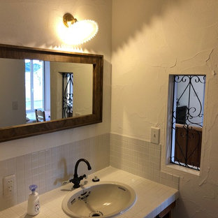 Foto di un bagno di servizio country con pareti bianche, top piastrellato, top bianco, pavimento in terracotta e pavimento arancione