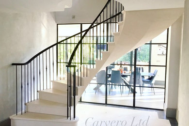 Photo of a large classic floating staircase in Other with limestone treads and limestone risers.