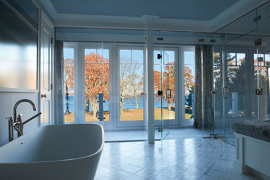 Inspiration for a huge modern master white tile and stone tile marble floor, white floor, double-sink and tray ceiling bathroom remodel in Providence with flat-panel cabinets, white cabinets, a two-piece toilet, blue walls, an undermount sink, a hinged shower door, white countertops and a built-in vanity