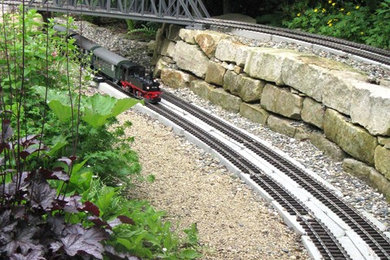 Großer Klassischer Garten neben dem Haus mit Natursteinplatten, Spielgerät und direkter Sonneneinstrahlung in Hannover