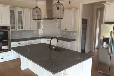 Inspiration for a mid-sized transitional l-shaped beige floor and medium tone wood floor eat-in kitchen remodel in Richmond with white cabinets, subway tile backsplash, stainless steel appliances, an island, an undermount sink, shaker cabinets, white backsplash, soapstone countertops and gray countertops