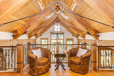 Inspiration for a large rustic loft-style medium tone wood floor family room remodel in Denver with white walls