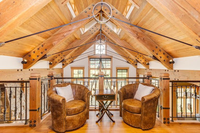 This is an example of a large country loft-style family room in Denver with medium hardwood floors and white walls.