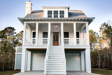 Photo of a mid-sized beach style two-storey white house exterior in Charleston with concrete fiberboard siding, a gable roof and a shingle roof.