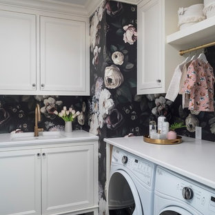 Inspiration for a classic l-shaped separated utility room in Minneapolis with a submerged sink, recessed-panel cabinets, white cabinets, black walls, a side by side washer and dryer, black floors and white worktops.