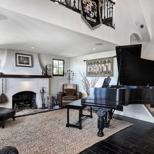 Modelo de salón abierto, mediterráneo, de tamaño medio, con paredes blancas, suelo de madera oscura, chimenea de doble cara, marco de chimenea de hormigón y suelo marrón