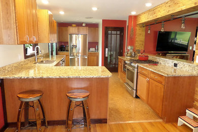 Kitchen - traditional medium tone wood floor kitchen idea in Cleveland with medium tone wood cabinets, granite countertops, stainless steel appliances and a double-bowl sink