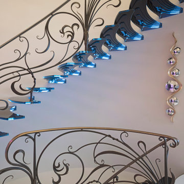Amazing floating staircase with cantileverd glass treads and artistic balustrade
