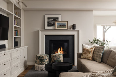 Living room library - small transitional open concept medium tone wood floor and brown floor living room library idea in Salt Lake City with beige walls, a standard fireplace, a wood fireplace surround and a media wall