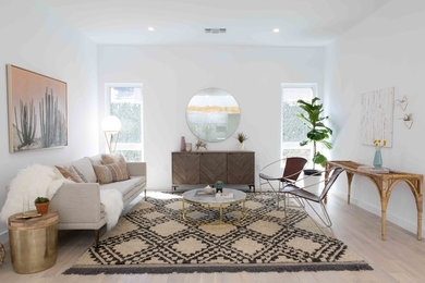Example of a trendy light wood floor and beige floor living room design in Los Angeles with white walls