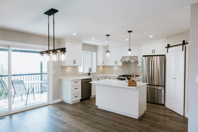 Large mountain style vinyl floor eat-in kitchen photo in Vancouver with an undermount sink, recessed-panel cabinets, white cabinets, quartzite countertops, beige backsplash, ceramic backsplash, stainless steel appliances and an island