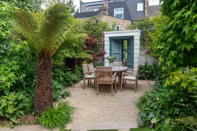 Inspiration for a small world-inspired back private partial sun garden in London with gravel.