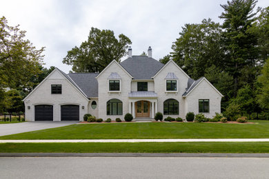 Inspiration for a large french country beige two-story brick exterior home remodel in Boston with a mixed material roof and a gray roof