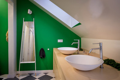 Example of a mid-sized danish master black and white tile and ceramic tile ceramic tile bathroom design in Other with furniture-like cabinets, light wood cabinets, a one-piece toilet, green walls, a pedestal sink and wood countertops