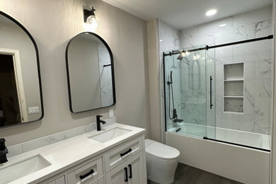 Mid-sized trendy kids' white tile and porcelain tile ceramic tile, gray floor and double-sink bathroom photo in Seattle with white cabinets, a bidet, gray walls, an undermount sink, quartz countertops, white countertops and a freestanding vanity