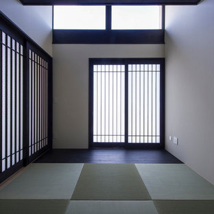 Asian entry hall in Nagoya with white walls, a sliding front door and tatami floors.