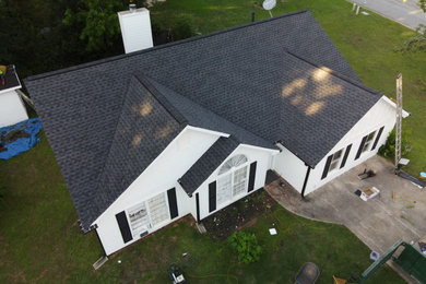 Modelo de fachada de casa blanca y negra de tamaño medio de una planta con revestimiento de madera, tejado a dos aguas y tejado de teja de madera