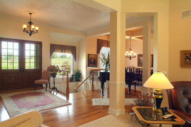 Entryway - mid-sized transitional light wood floor entryway idea in Other with beige walls and a medium wood front door